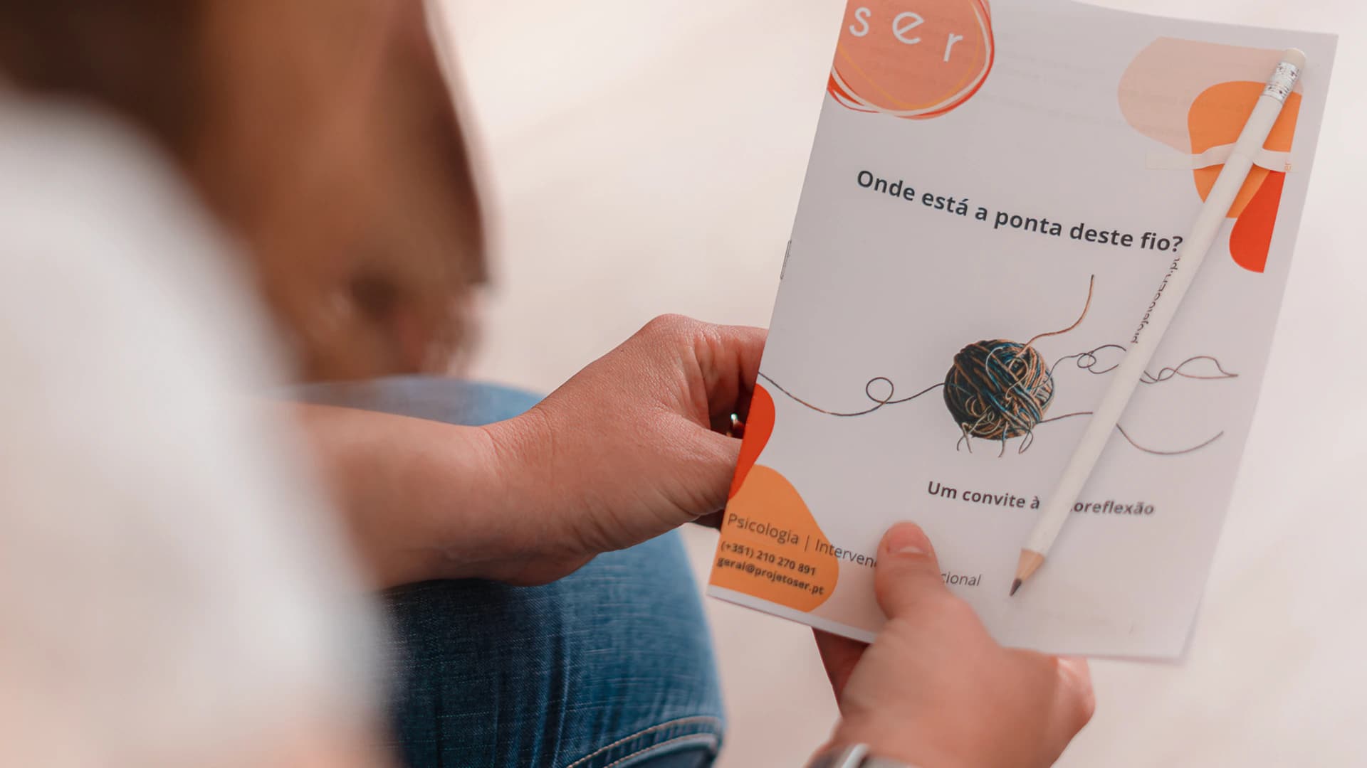 Pessoa a ler um folheto de formação do Projeto SER